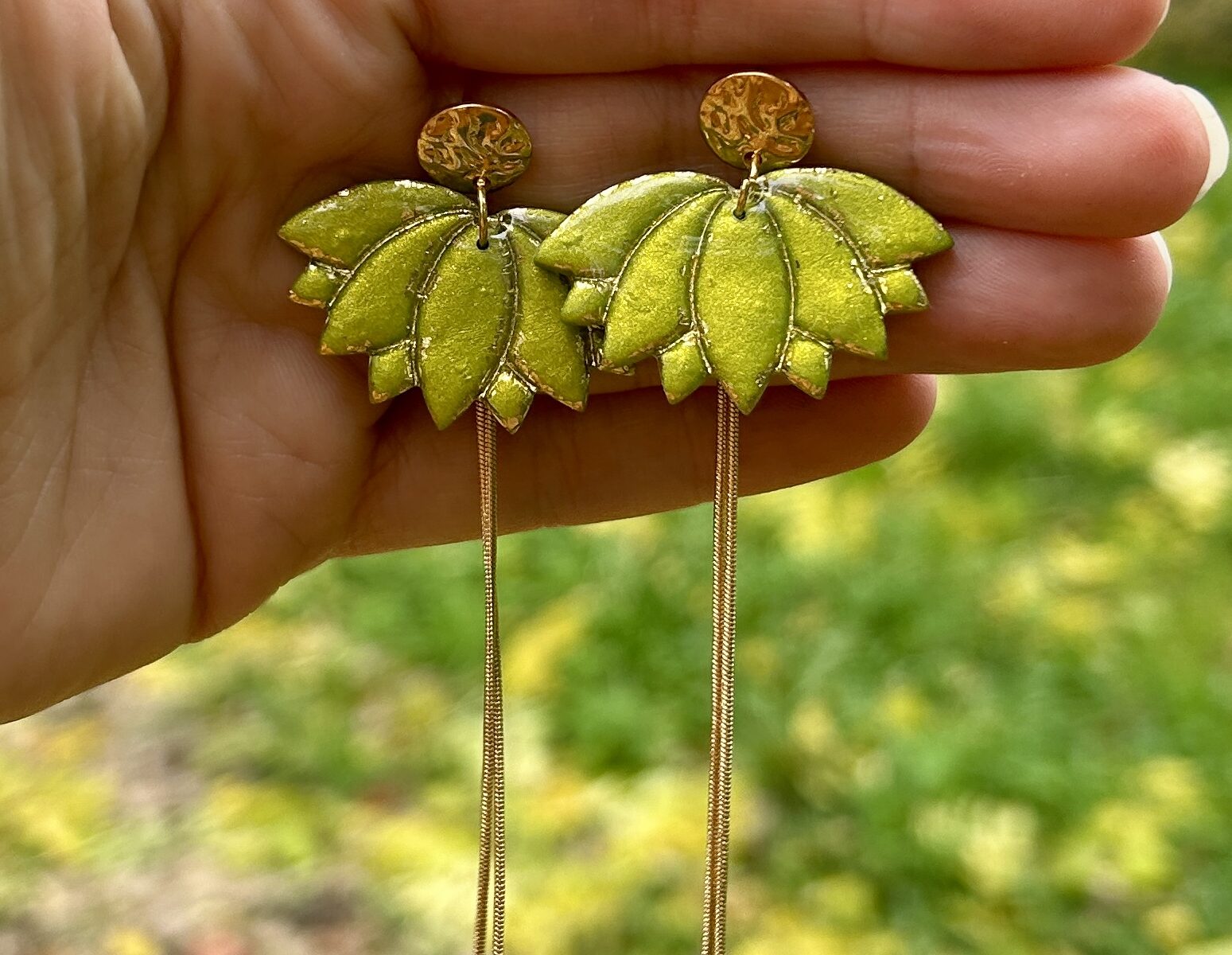 presentation d'une paire de boucle d'oreilles en forme de lotus de couleur vert