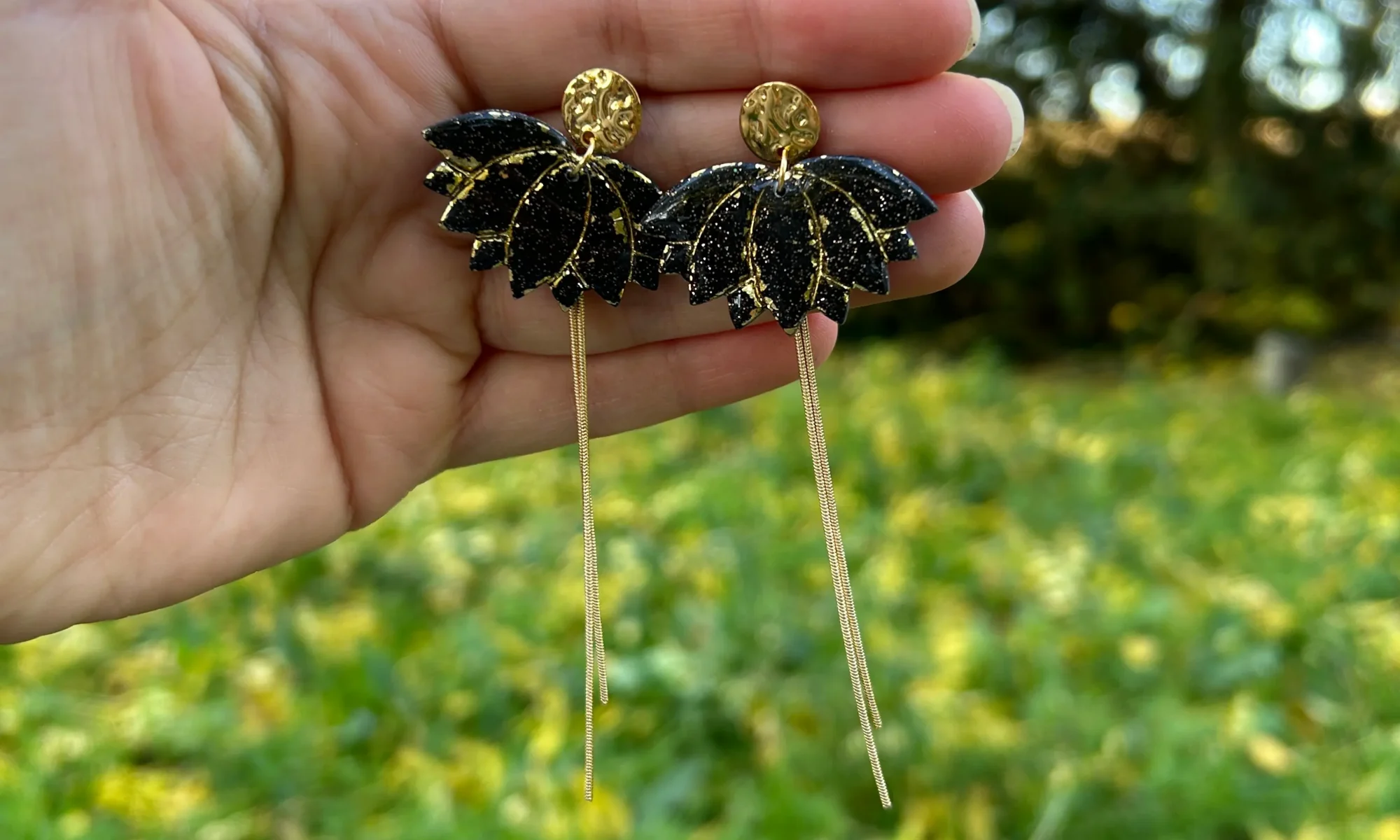 Boucles d'oreilles fleur de lotus portée pour une main