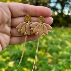 Présentation boucles d'oreilles en forme de fleur de lotus de couleur beige avec de la dorure