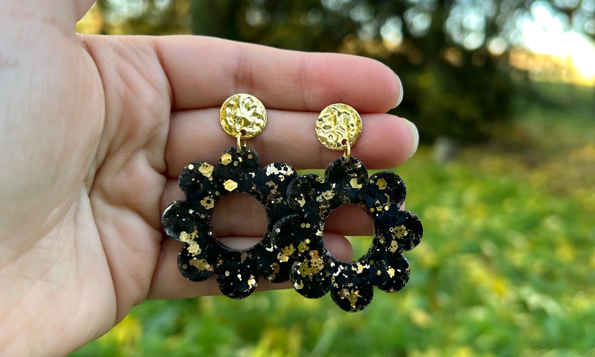 boucles d'oreilles résine paillette noire dorée forme marguerite