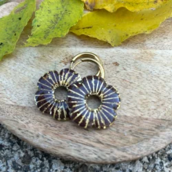 présentation de bijoux pour créoles interchangeables en forme de coquelicot et couleur marron sur un plateau