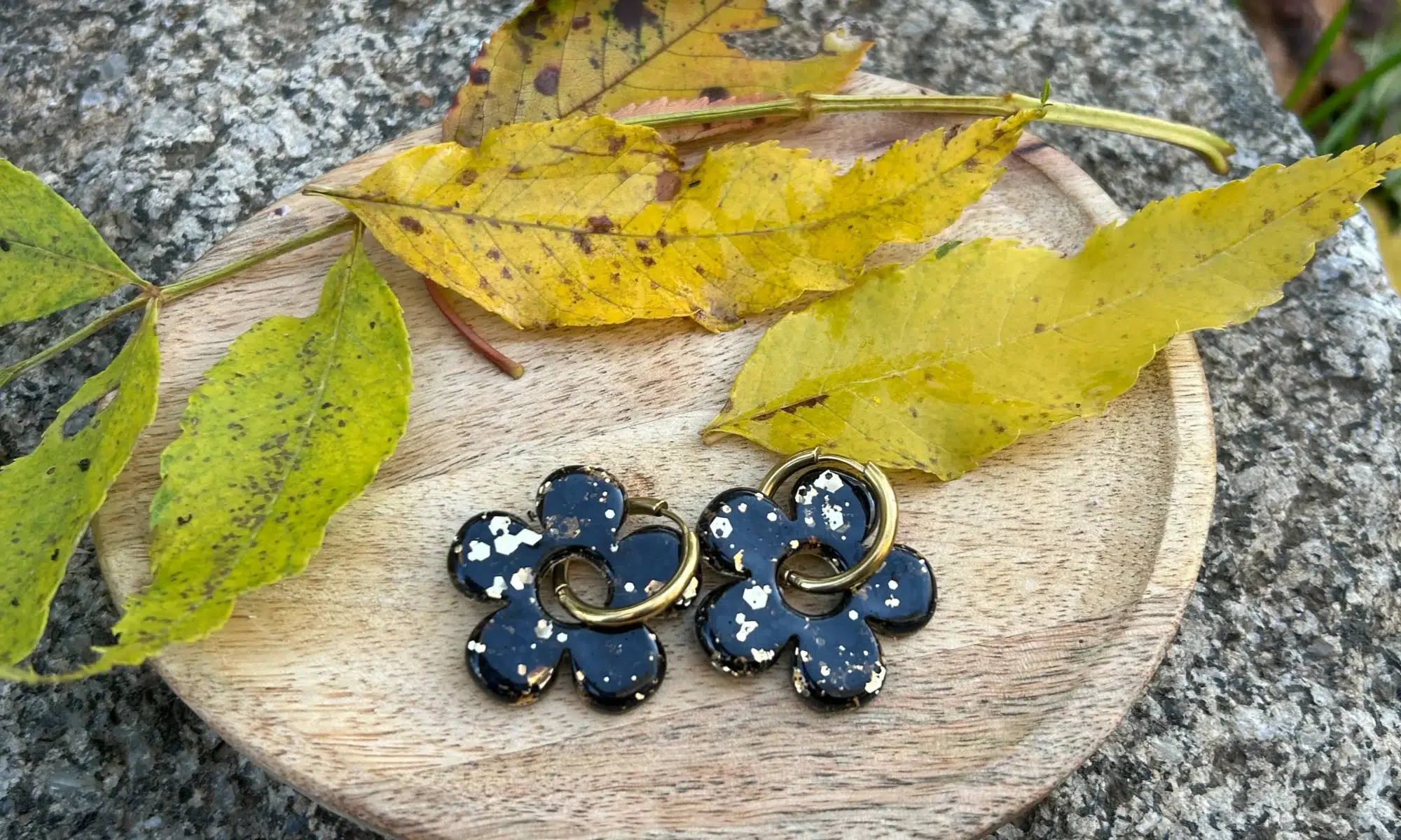 présentatio paimpilles en résine en forme de fleur en noir et doré sur un plateau avec de la déco