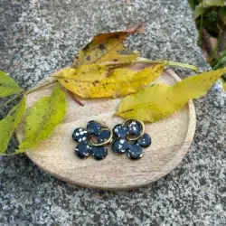 présentatio paimpilles en résine en forme de fleur en noir et doré sur un plateau avec de la déco