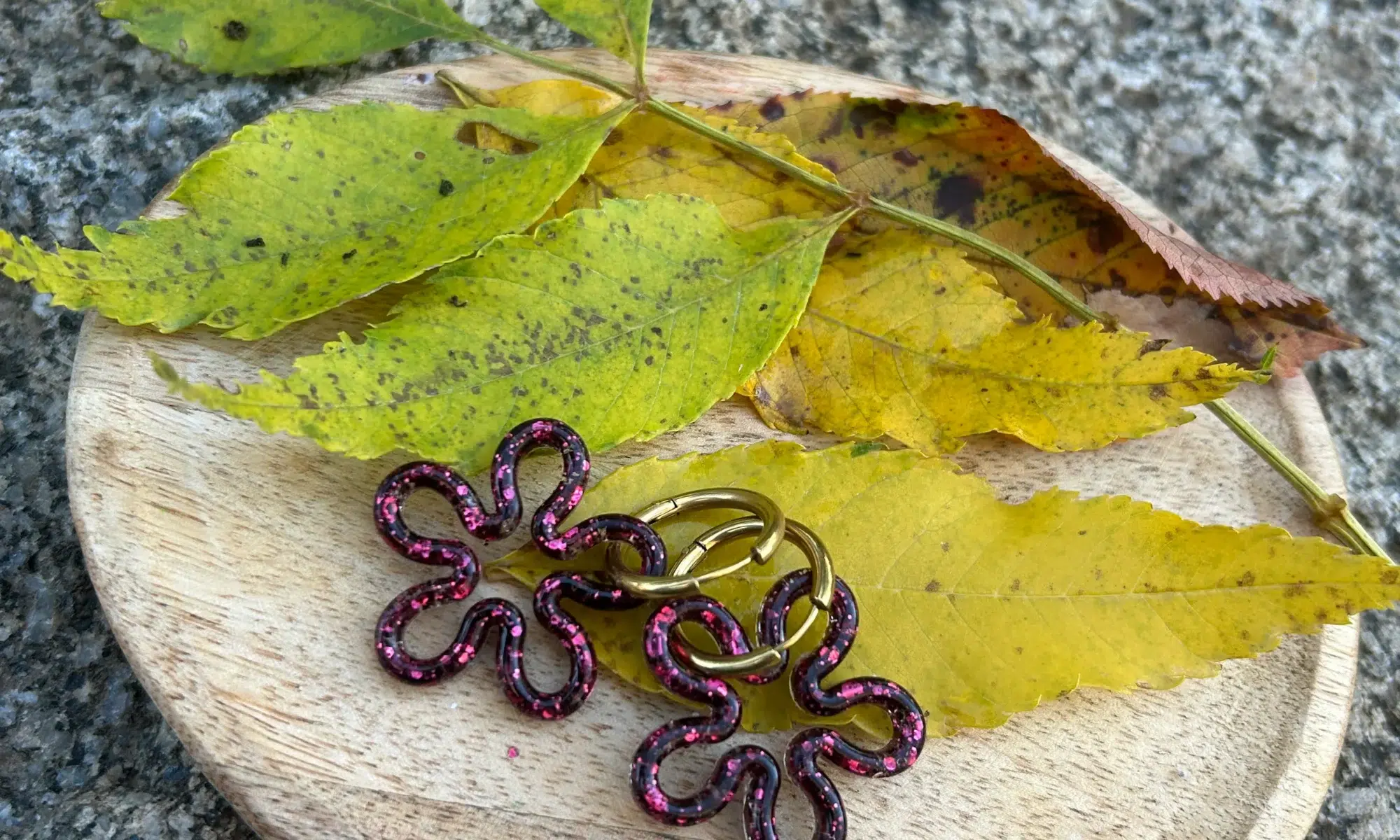 présentation paires de boucles d'oreilles en forme de fleur en résine pailletée fuchsia