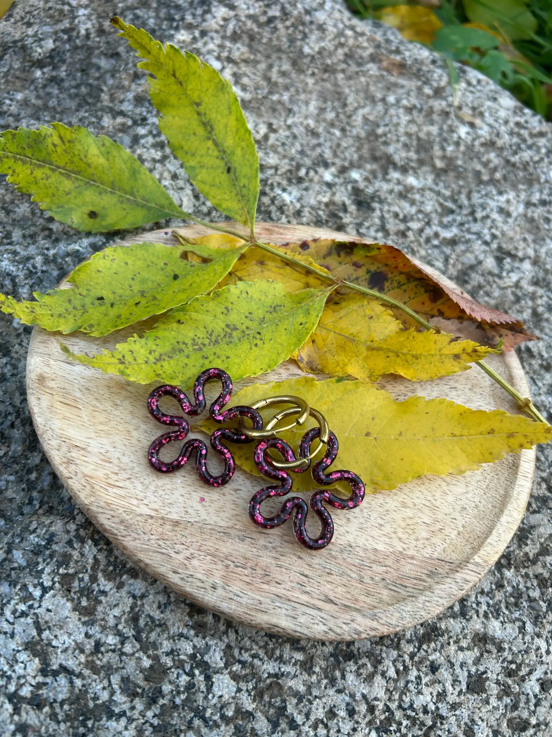 présentation paires de boucles d'oreilles en forme de fleur en résine pailletée fuchsia