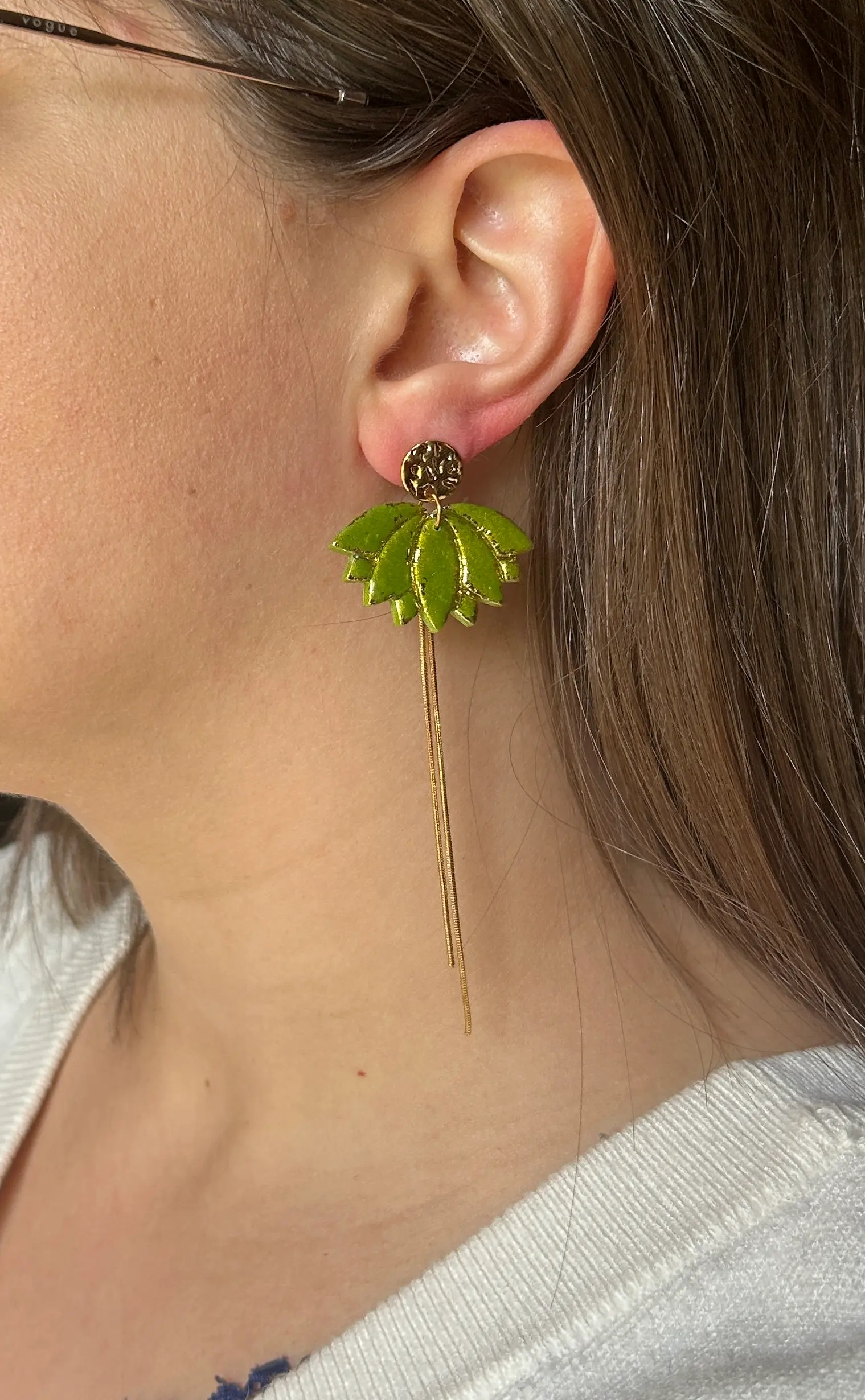 boucles d'oreilles en forme de lotus de couleur verte, porté.